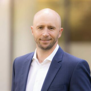Volker Ludwig, Managing Director Germany at Digital Realty, smiling in a blue suit and white shirt against a softly blurred background.