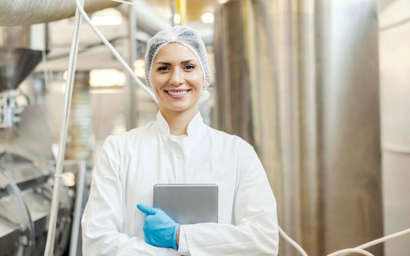 Mitarbeiterin in der Produktion der Lebensmittelindustrie hält ein Tablet in der Hand