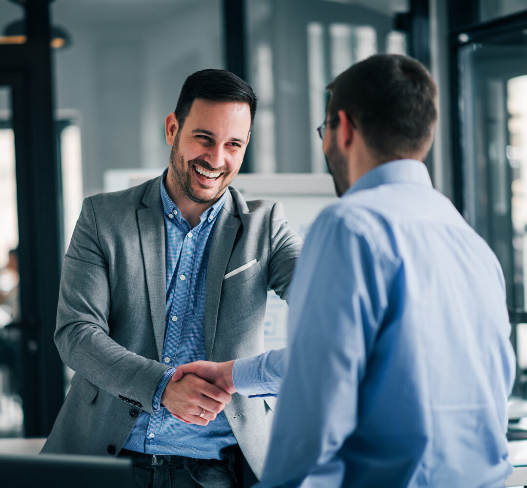 Portrait of cheerful young manager handshake with employee.