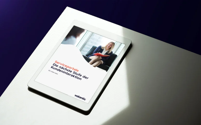 Eine Frau lächelt, während sie an einem Schreibtisch sitzt und an einem Projekt arbeitet.