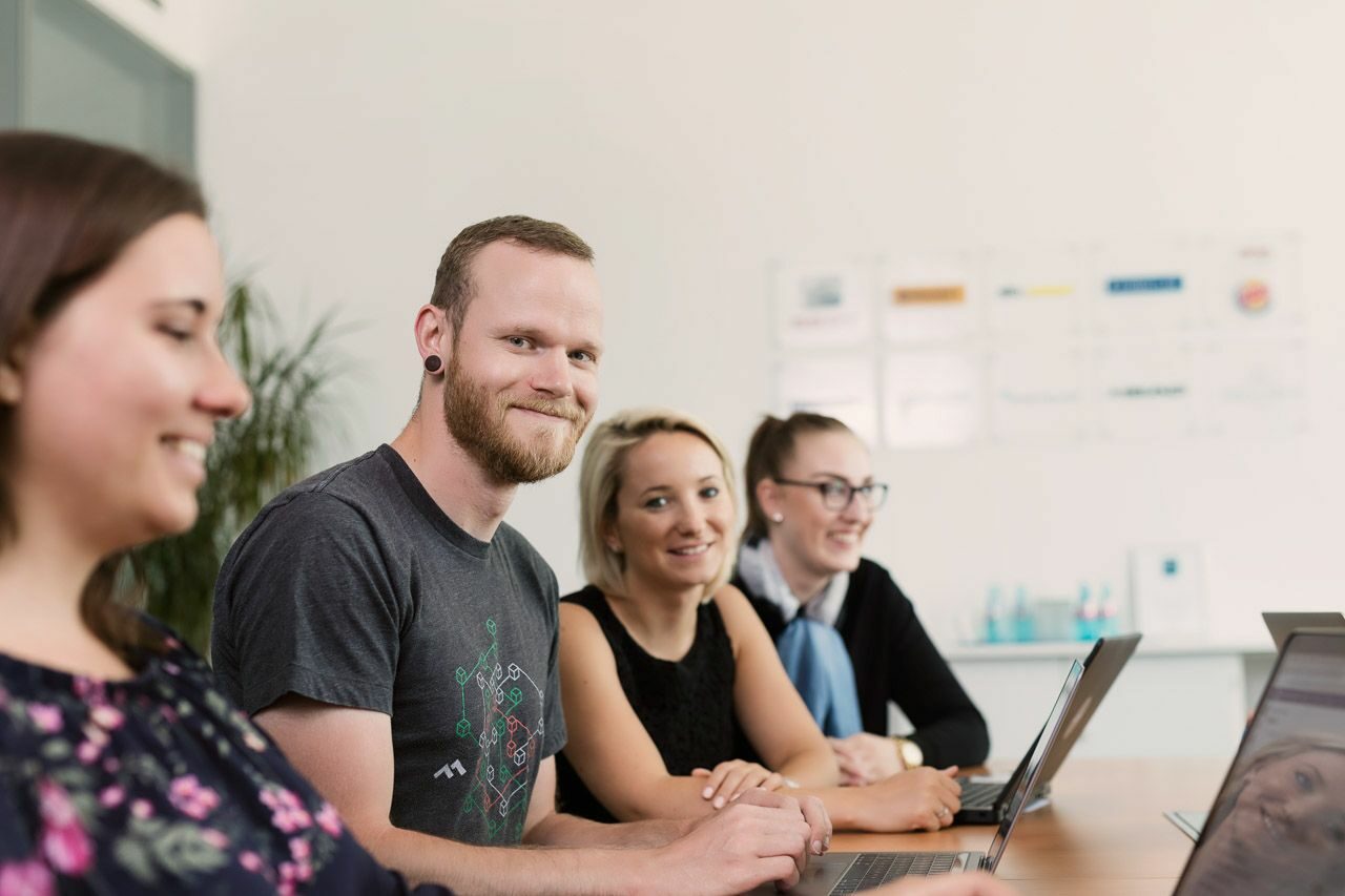 Team members are having a discussion at the table about current work matters.