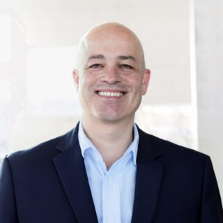 Ralf Werner, Chief Information and Digital Officer at Open Grid Europe, smiling in a business portrait wearing a dark suit and light blue shirt.