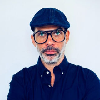 Rodrigo Castelo, Vice President EMEA at OutSystems, wearing a dark shirt and cap, looking confidently at the camera.