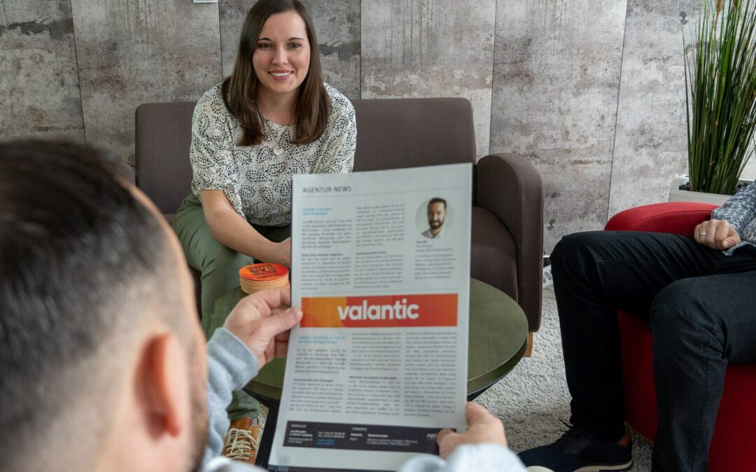 Ein Mann und eine Frau entspannen sich in einem Stuhl und betrachten eine Zeitung.