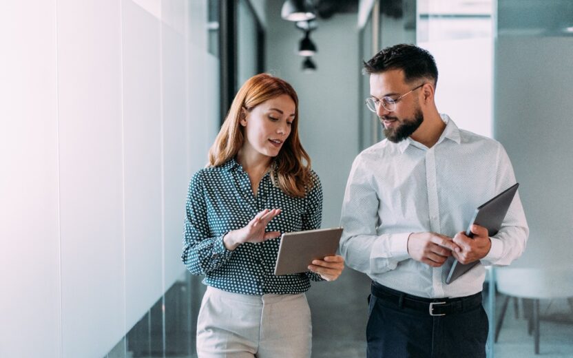 a woman and a man disussing instandhaltungsplanung mit sap ibp for mro while walking down the office floor