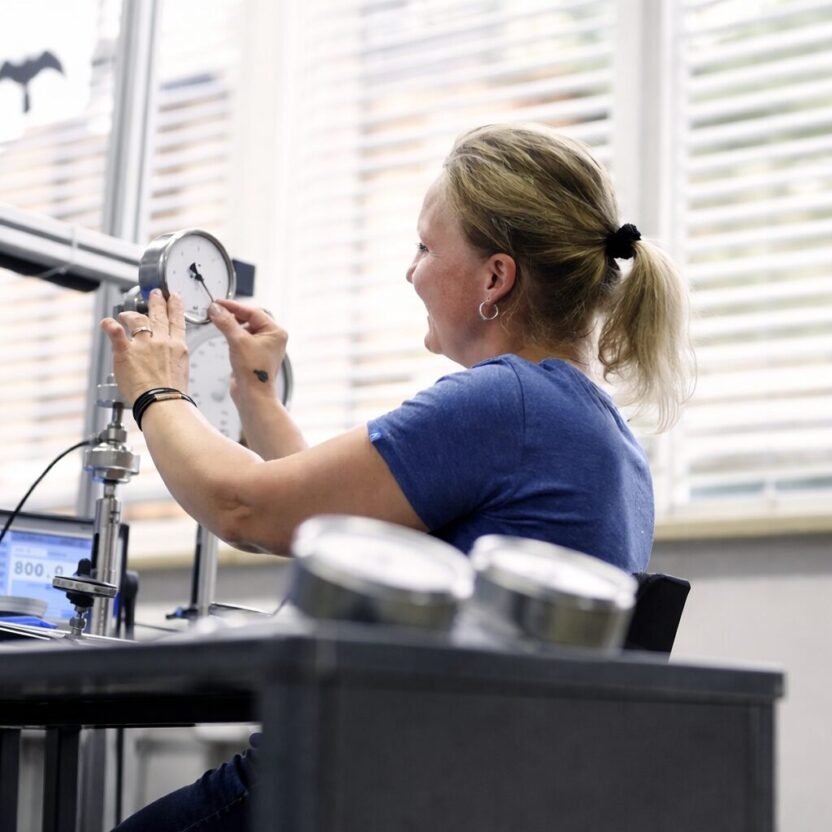An employee of AFRISO Euro Index GmbH is working on a measuring and analysis device