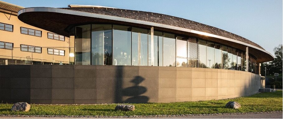 Modern glass-fronted circular office building at the Marc O'Polo