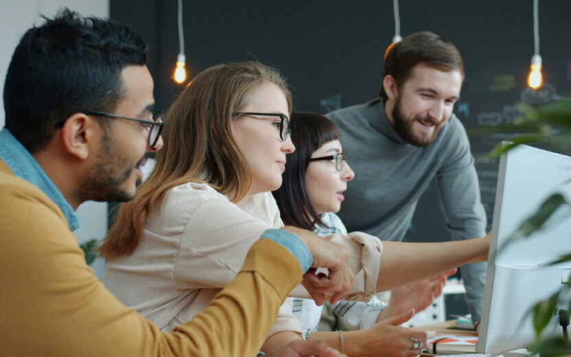 Vier Personen arbeiten gemeinsam am Computer und testen das valantic KI Tool für die Migration von Daten in ihrem SAP S/4HANA Projekt