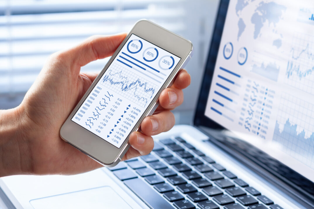 Inversor analizando el mercado de valores con un cuadro de mando financiero en un smartphone o un ordenador | Análisis e informes con SAP Analytics