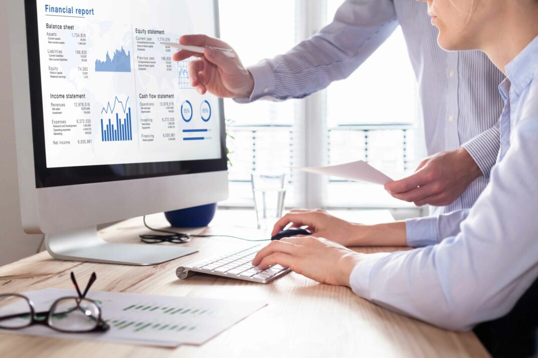 Informe Financiero en una pantalla con dos personas trabajando | Planificación y Consolidación con SAP Analytics