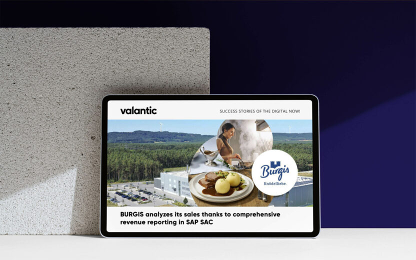 The tablet showcases a business success story about BURGIS, enhanced by SAP Analytics Cloud, featuring a stunning landscape view beside a tempting plate of food.