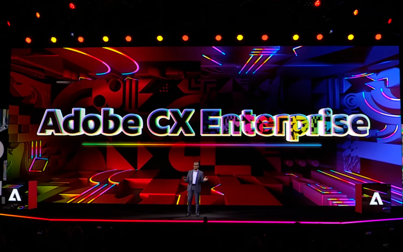 Bühnenpräsentation beim Adobe Summit 2026 in knalligen Farben. Ein Speaker stellt die neue Adobe CX Enterprise Solution vor.