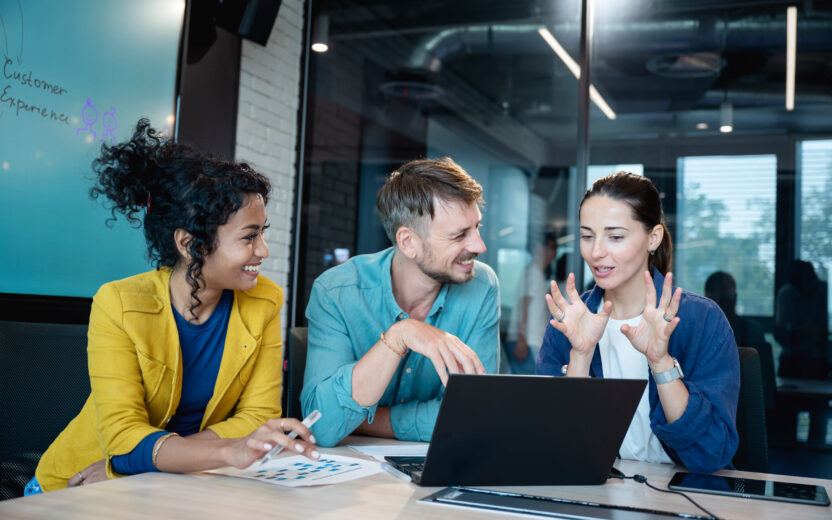 Gruppe von drei Personen diskutiert am Laptop die Ergebnisse der valantic SAP Studie 2026