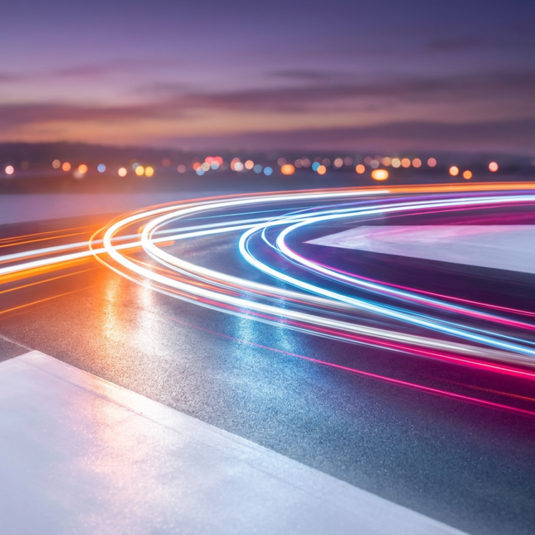 Colorful light trails curving along a road at dusk
