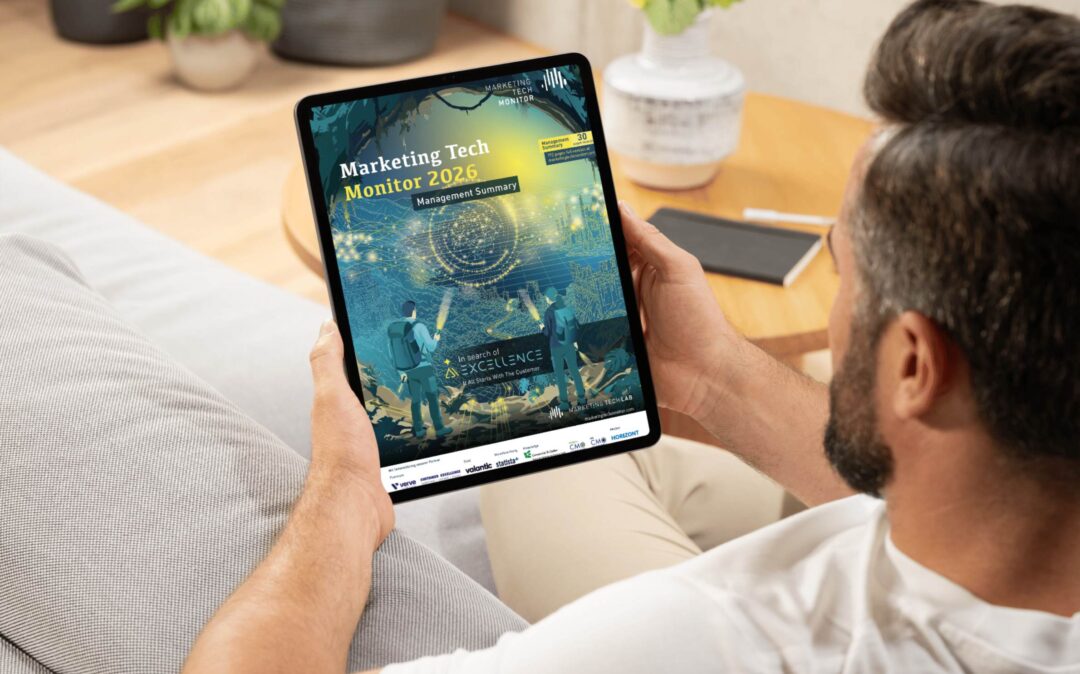 Mann auf einem Sofa liest die Management Summary zum Marketing Tech Monitor 2026 auf einem Tablet.