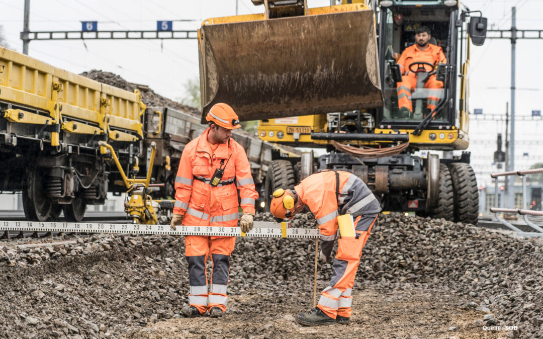 Three men working rail consteuctions.
