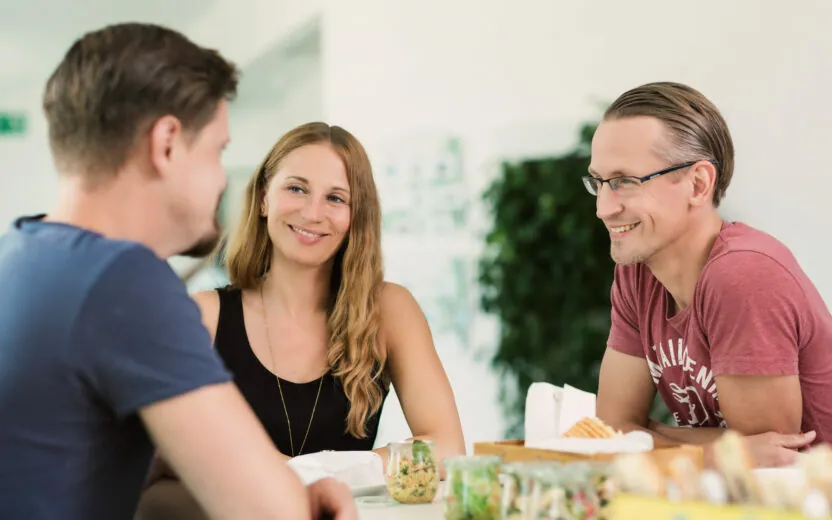 Bild von drei lächelnden Personen im Gespräch, valantic Niederlassung netz98 Mainz
