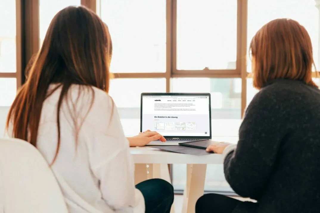 Bild von zwei Frauen vor einem Laptop, valantic Case Study Peter Jensen IBM Cognos Business Analytics