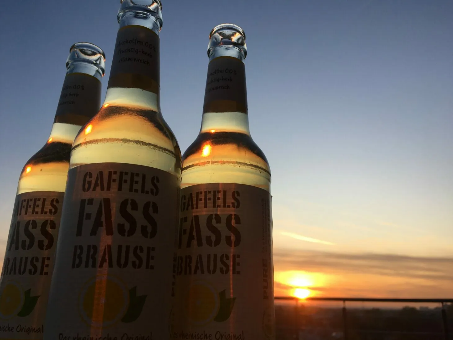 Bild von drei Flaschen Fassbrause vor dem Sonnenuntergang, valantic Niederlassung Siegburg