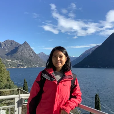 Über uns - Team - Bild von Cissy Hu, User Experience Specialist at valantic, mit Gewässer und Bergen im Hintergrund