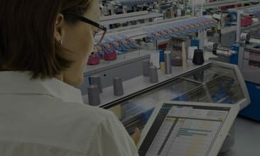 Picture of a woman with a tablet in a production plant, valantic Case Study Stoll