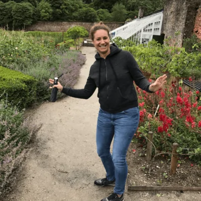 About us - Team - Picture of Nicole Heim, Finance and Human Resources Manager at valantic, in a garden