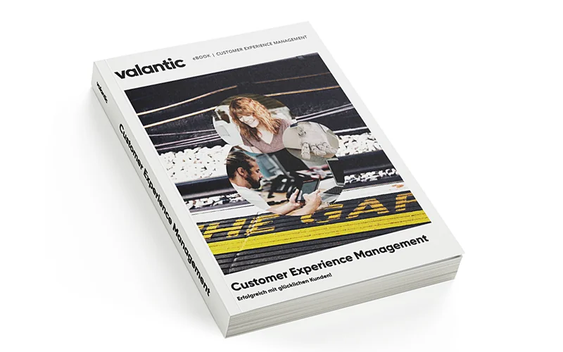 Hier sehen Sie die Ansicht unseres E-Books zum Thema Customer Experience Management. Ein Dreiklang aus einer lächelnden, arbeitenden Frau, einem arbeitenden Mann am Tablet und einer Roboterhand.
