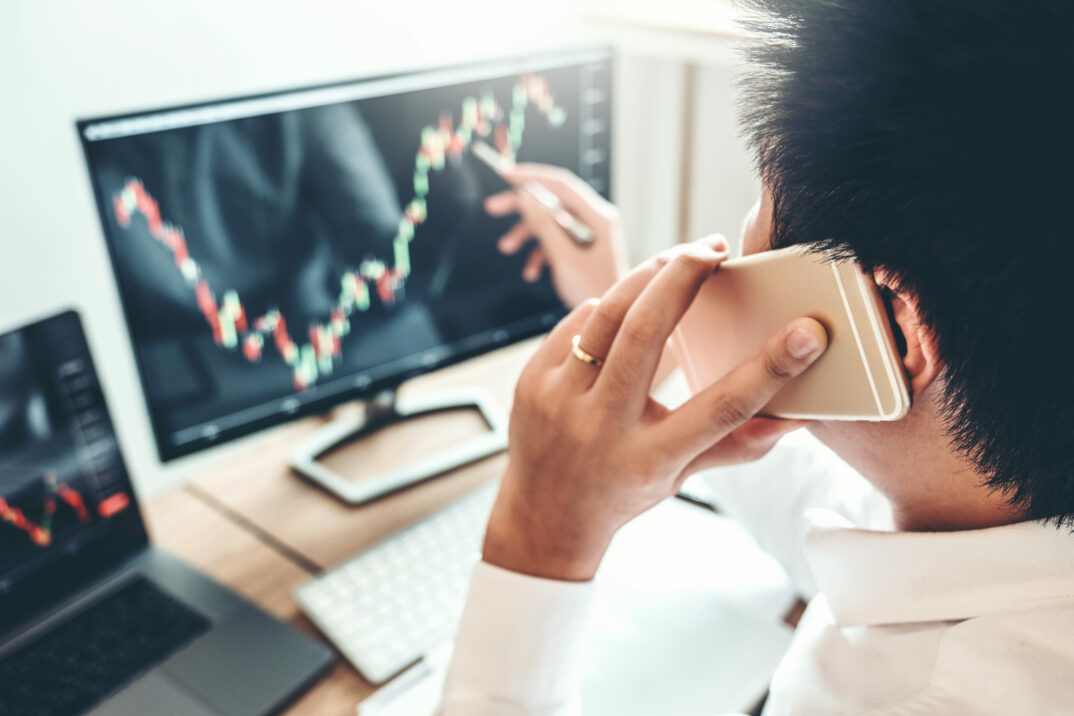 Bild eines Mannes, der auf einen Laptop Bildschirm mit einer Grafik schaut, Investment Stock Market