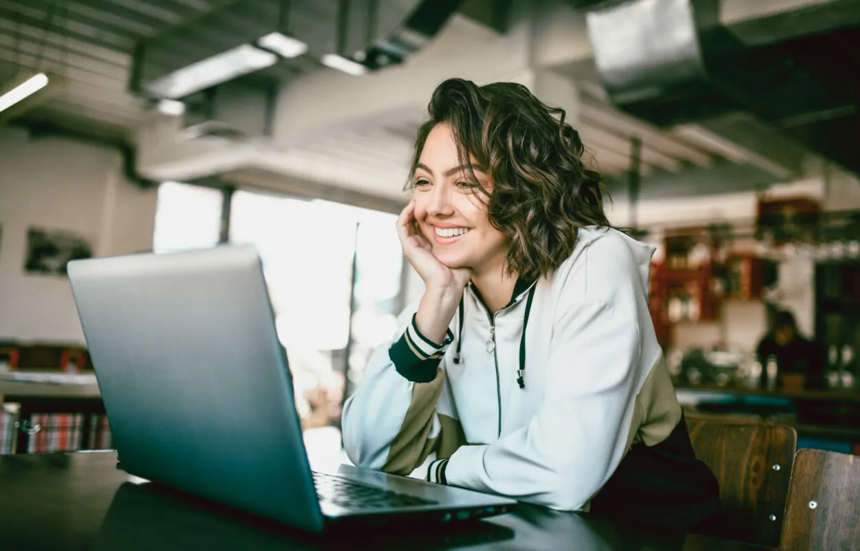 Bild einer lächelnden Frau, die in einen Laptop schaut