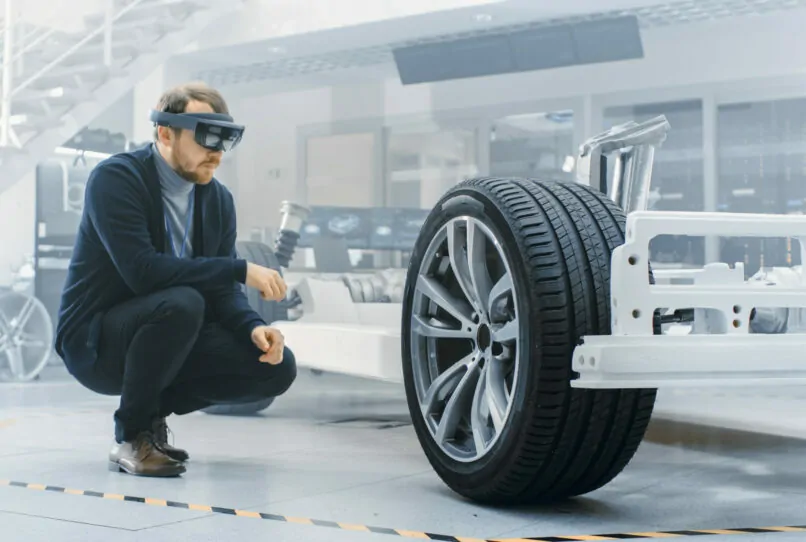Bild eines Automotive Ingenieurs, der mithilfe einer VR-Brille an einem Auto arbeitet, Trend in der Automotive-Industrie: Industrie 4.0, KI Automotive