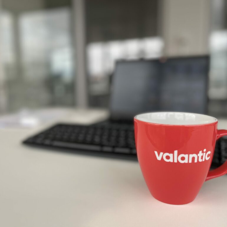Bild eines Arbeitsplatzes der valantic Niederlassung Zürich mit Blick auf eine Kaffeetasse und Laptop