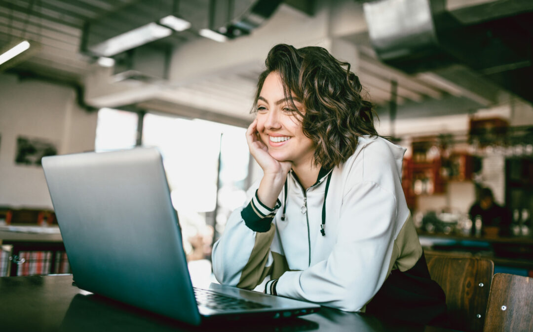Image of a smiling woman looking into a laptop, trends in the automotive industry: Customer Experience