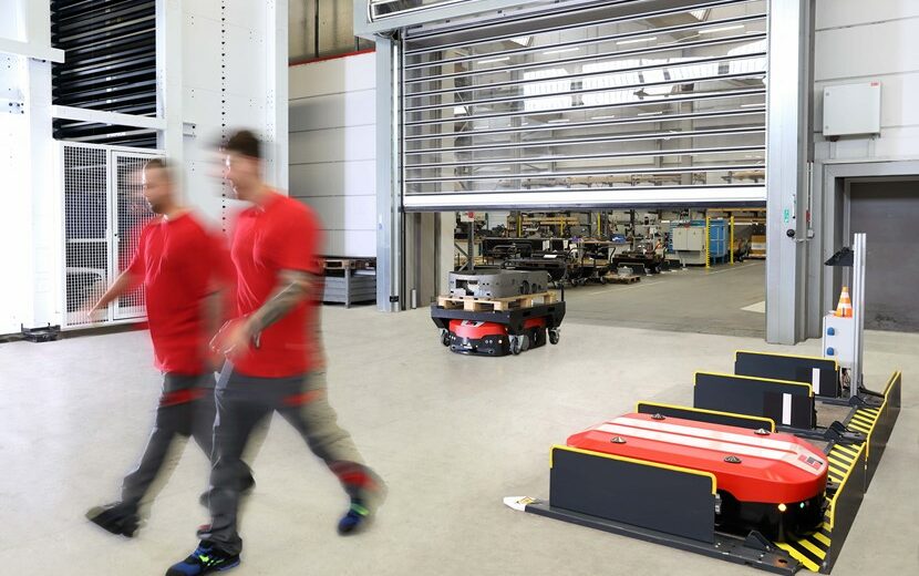 Bild von zwei Personen sowie dem fahrerlosen Transportsystemen bei Grenzebach