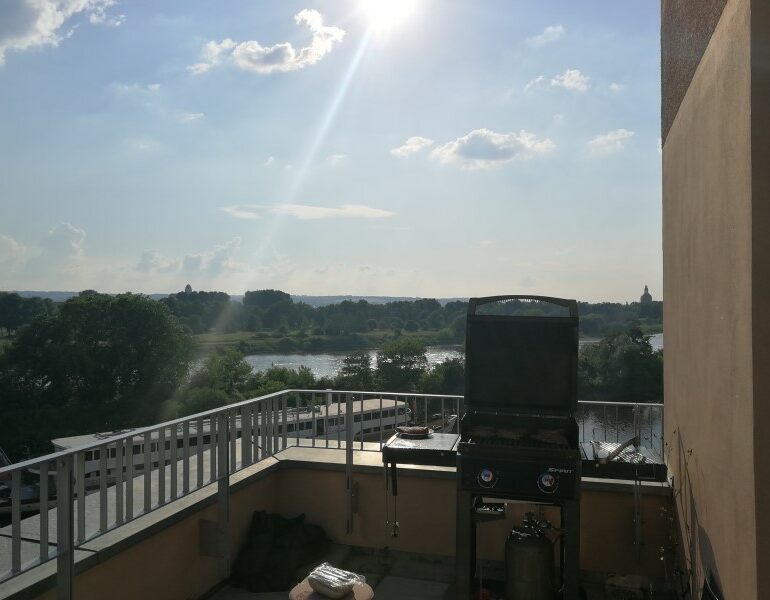 Foto aus dem valantic ERP Consulting Büro in Dresden mit Blick auf den Balkon, Office-Grill und Elbe