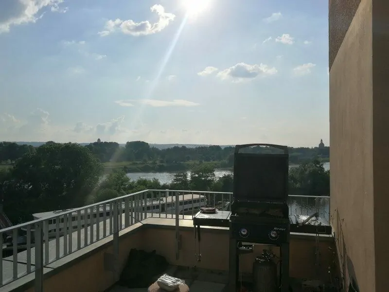Photo from the valantic ERP Consulting office in Dresden with a view of the balcony, office bbq and the river Elbe