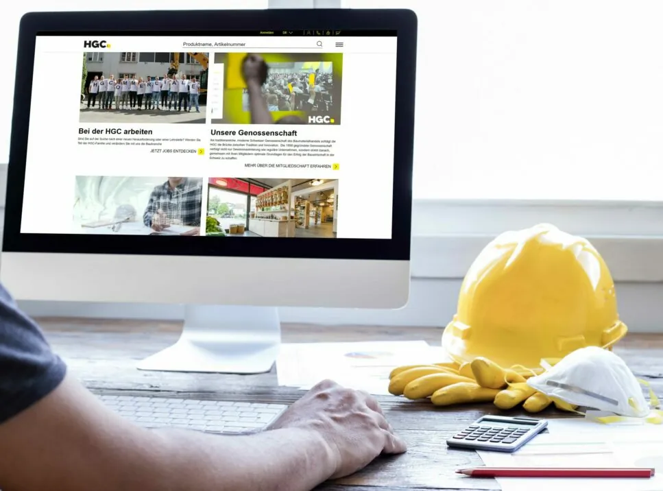 Image of a desk with a laptop and a construction helmet, valantic case study: e-commerce & corporate platform for HGC with SAP Commerce Cloud