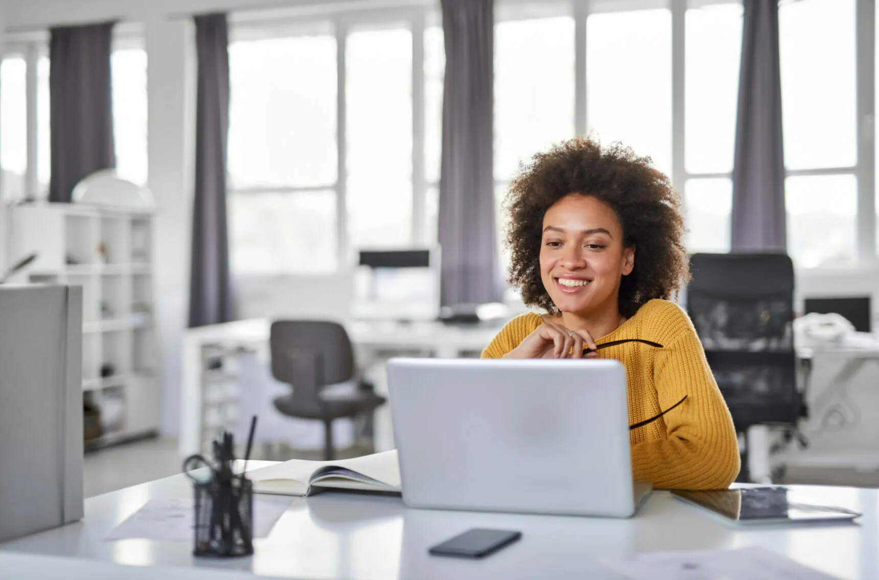 Businesswoman using laptop in office. | Automatisiertes Upgrade mit Motio