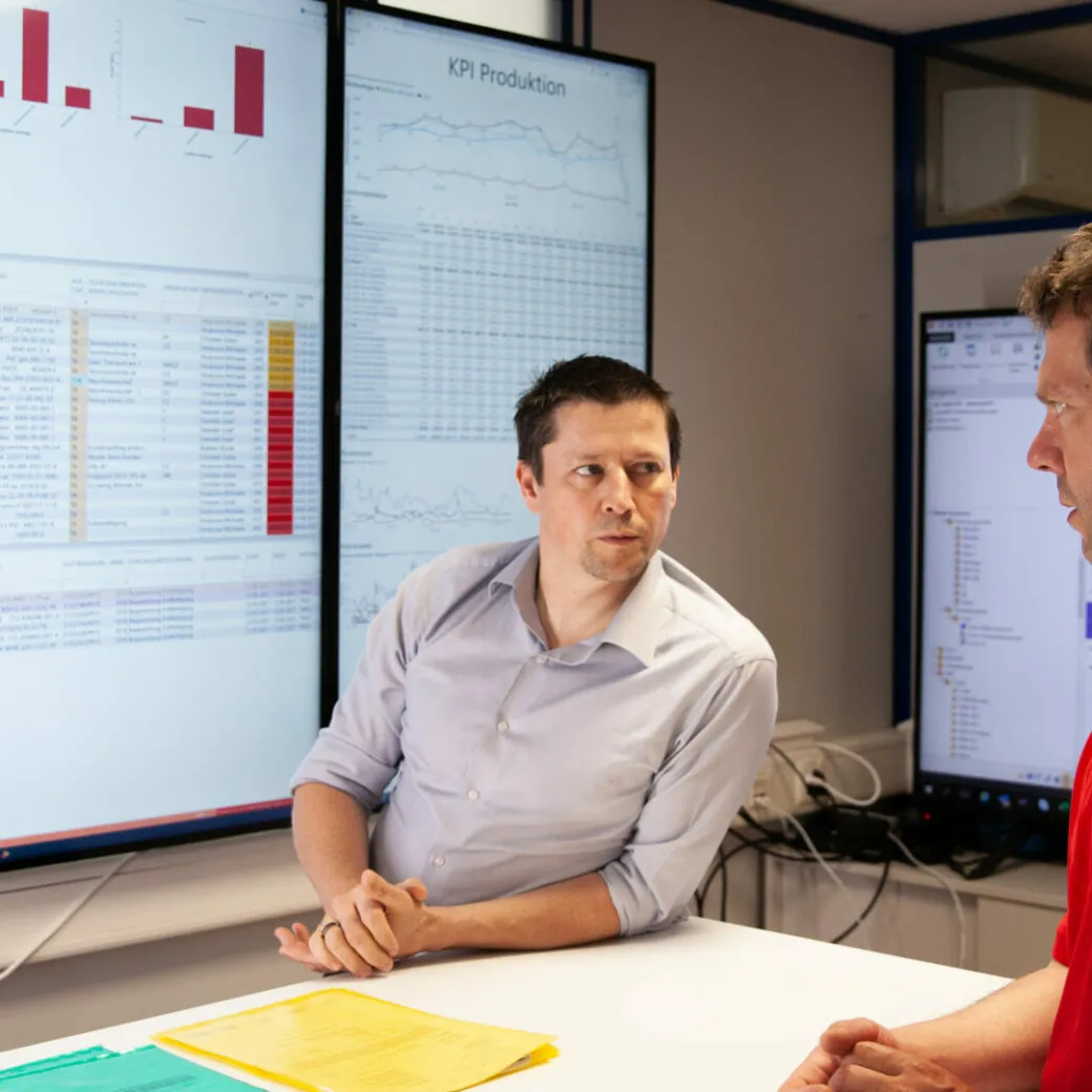 Bild von zwei Personen an einem Tisch mit Planungsunterlagen, valantic führt Mehrwerkeplanung bei Behr Bircher Cellpack BBC ein