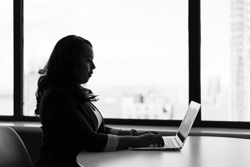 Bild von einer Frau, die am Schreibtisch und vor einem Laptop sitzt, Digital.Now Magazin Umsätze in der IT steigen an