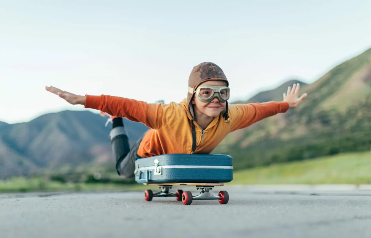 Bild von einem Kind mit Pilotenhaube, das auf einem Koffer surft; Digital Now Magazin valantic, Customer Journey