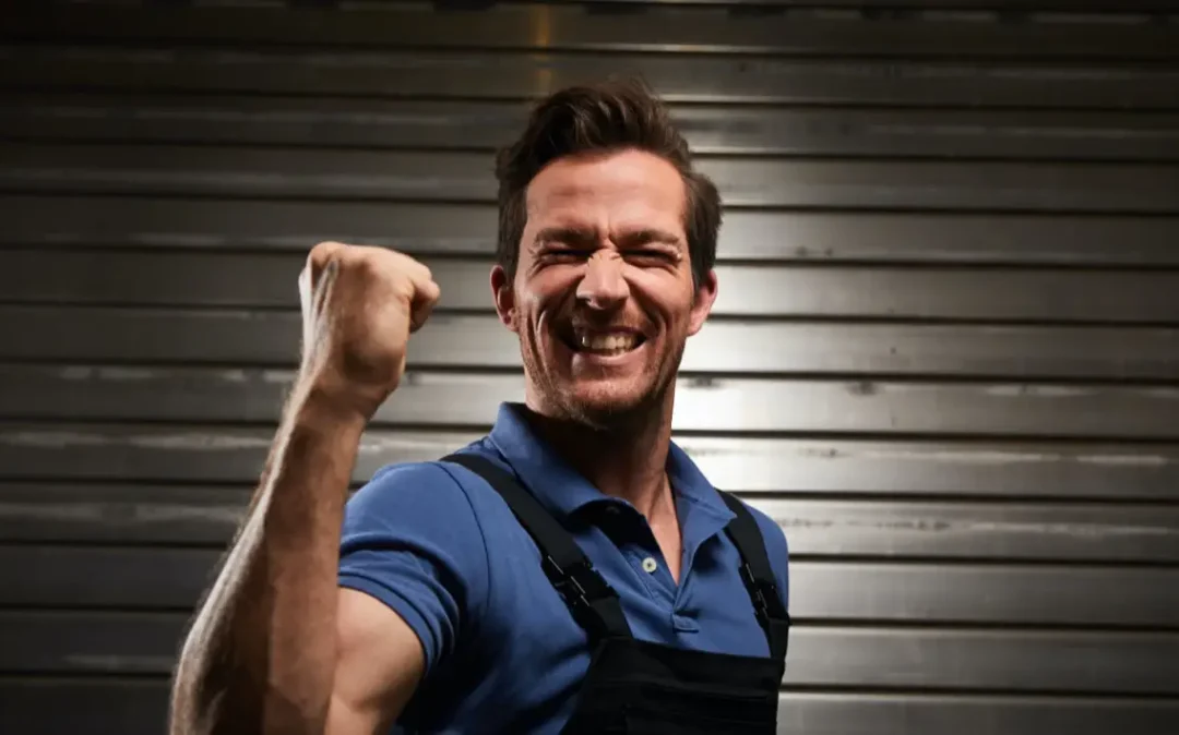 Ein Handwerker freut sich und hält die Faust angewinkelt nach oben