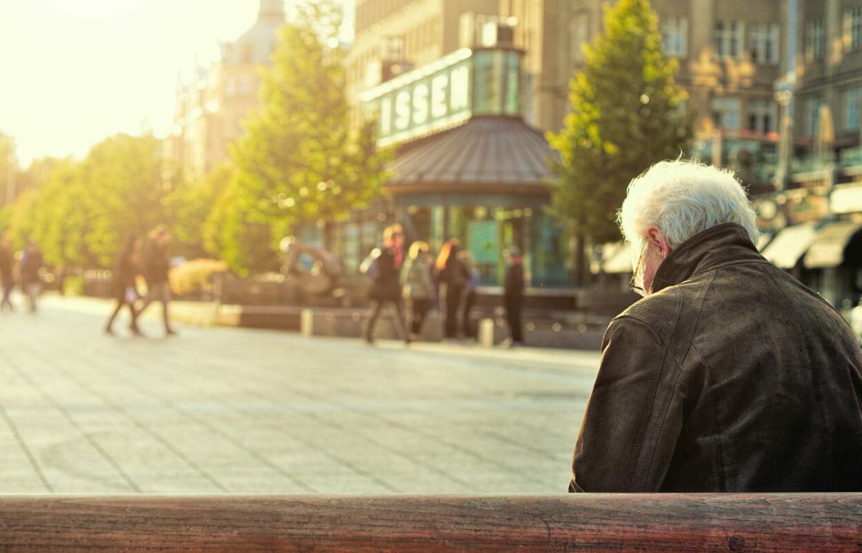 Bild von einem älteren Mann, der auf einer Bank sitzt, Personalmanagement & New Work