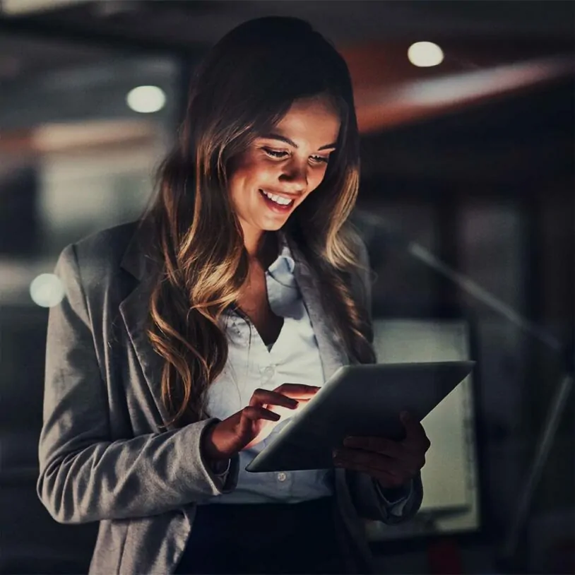 Image of smiling woman looking into tablet; valantic Financial Services Automation (FSA)