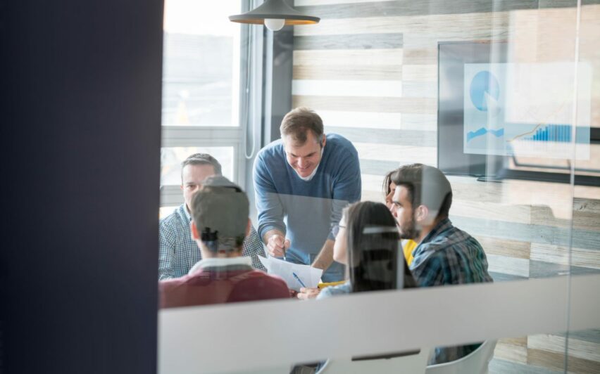 Bild von einer Gruppe von Menschen, die in einem Besprechungsraum sitzen, SAP Konsolidierung