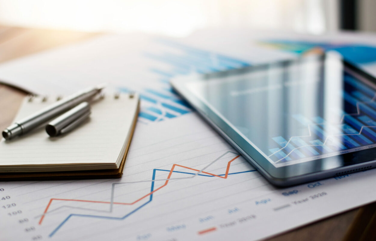 Geschäftsdokumentbericht auf Papier und Tablet mit Verkaufsdaten und Finanzgeschäftswachstumsdiagramm auf Tabellenhintergrund, SAP glänzt in der Cloud