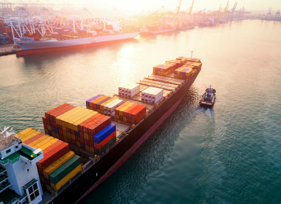 Bild eines Containerschiffes, das in einen Industriehafen einläuft; valantic Smart Industries & Industrie 4.0
