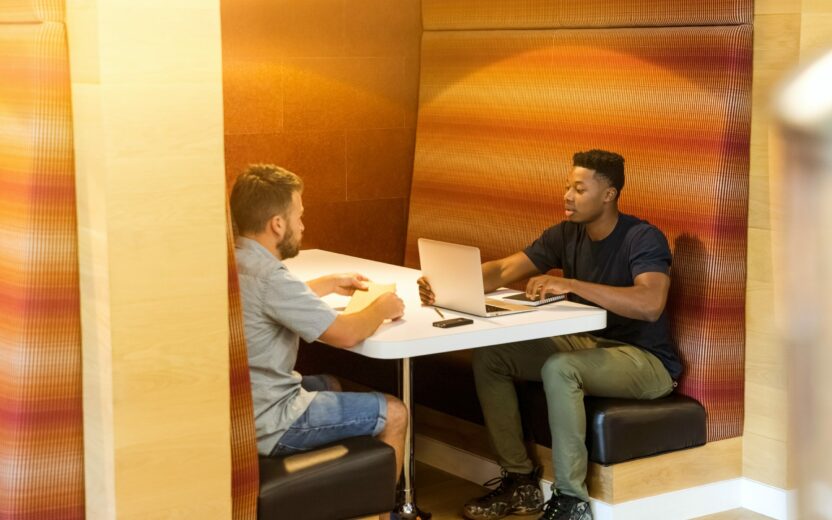Picture of two young men sitting opposite each other and working together