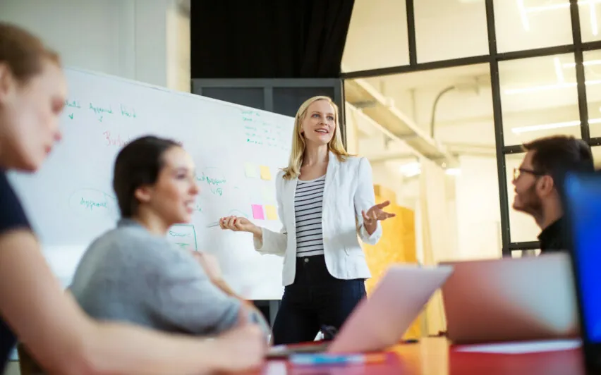 Young businesswoman giving presentation on future plans to her colleagues at office