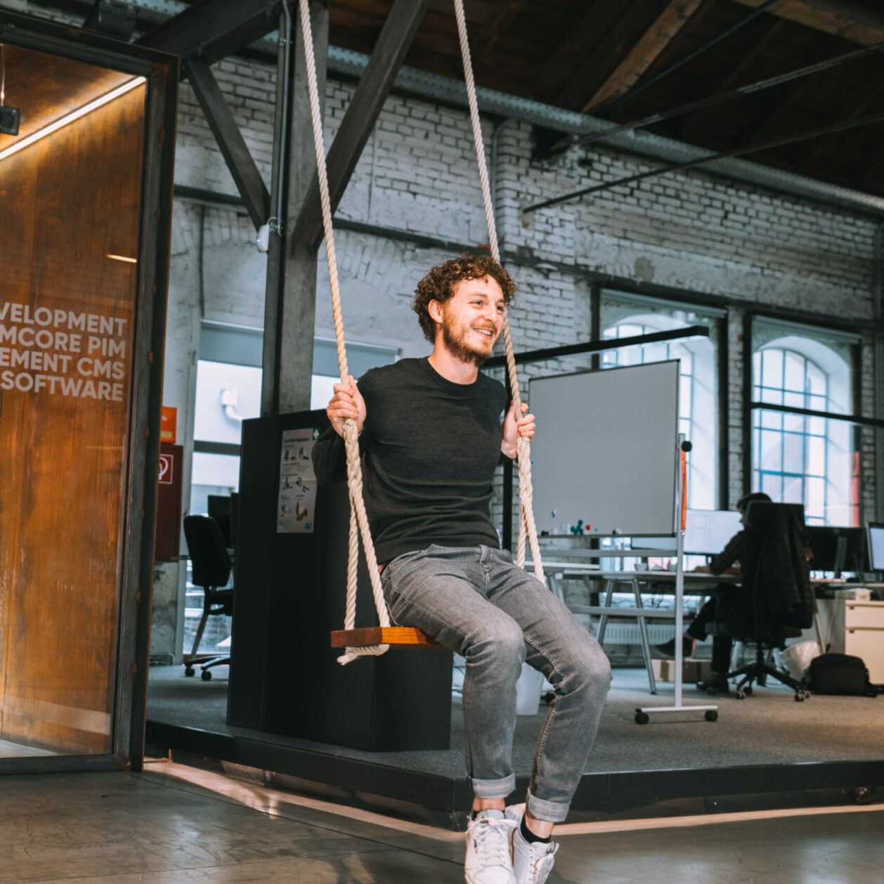 Image of man spending his break on a swing in the office.