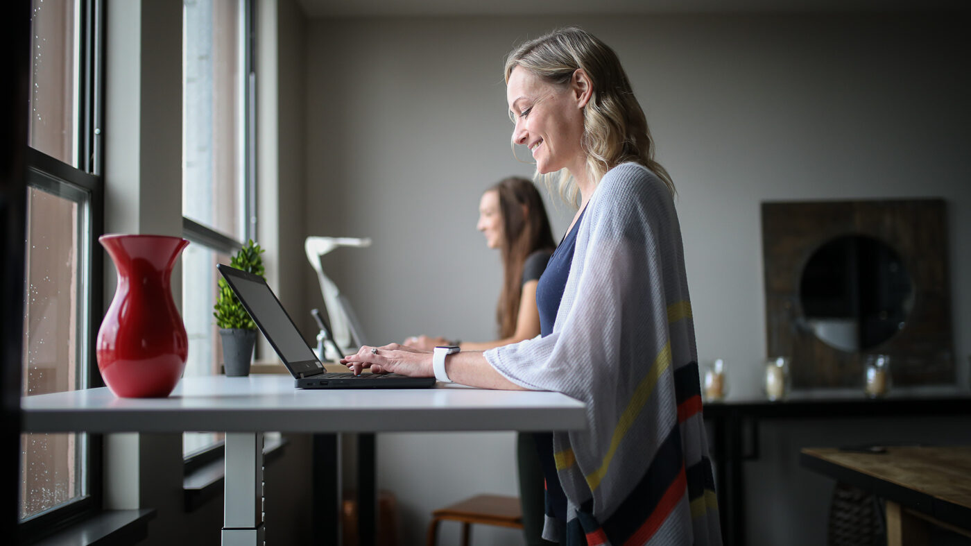 Picture of two women working at standing desks.